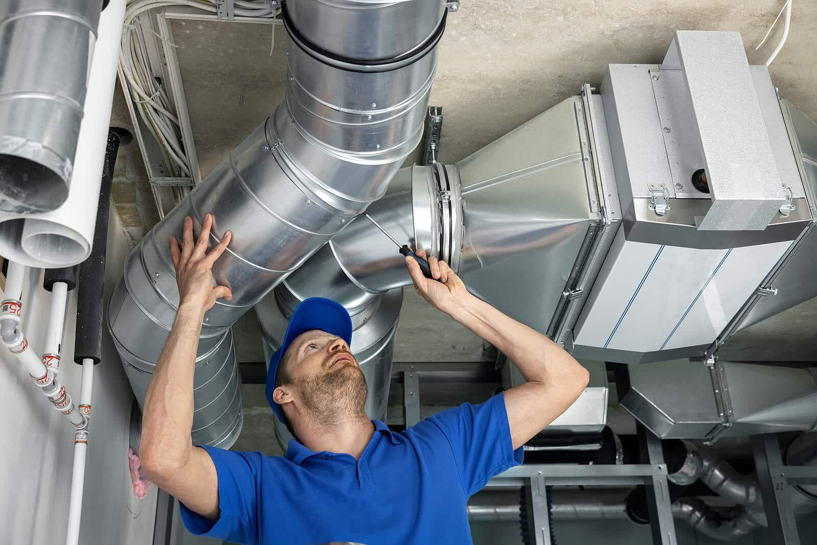 HVAC technician inspecting and repairing air ducts in Fountain Valley