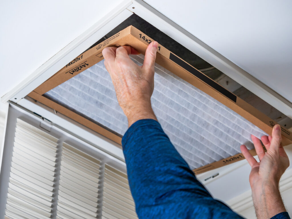HVAC technician replacing a home air filter in Fountain Valley
