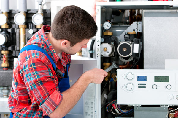 Heating technician repairing boiler controls in Fountain Valley