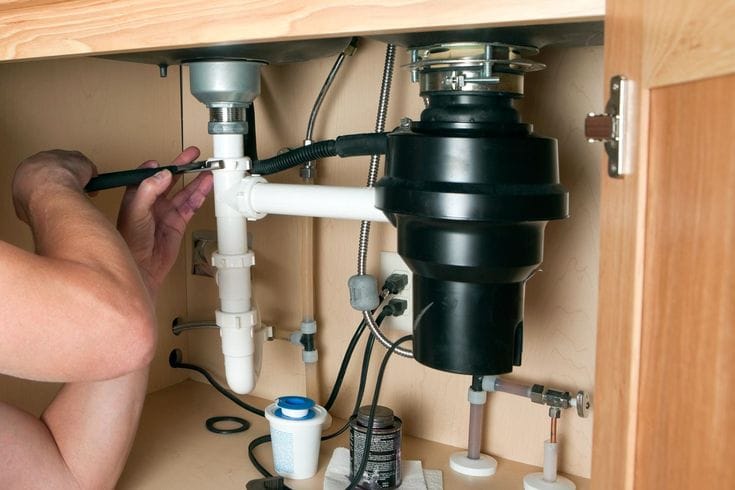 Plumber repairing a garbage disposal in Fountain Valley