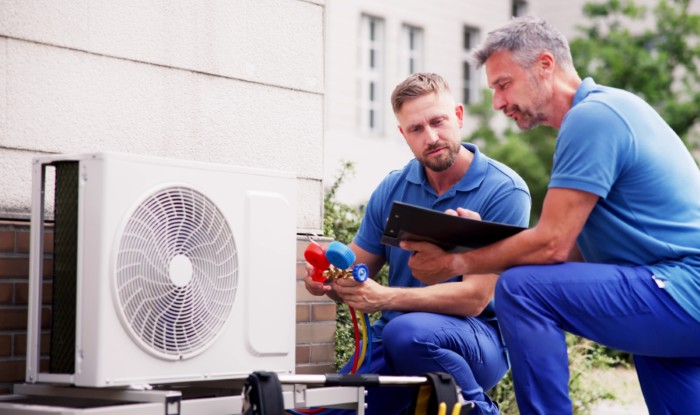 HVAC technicians installing an outdoor air conditioning unit in Fountain Valley