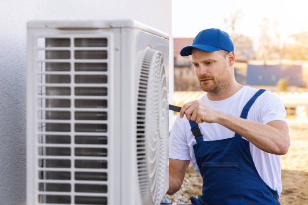 HVAC technician servicing an outdoor air conditioner in Fountain Valley